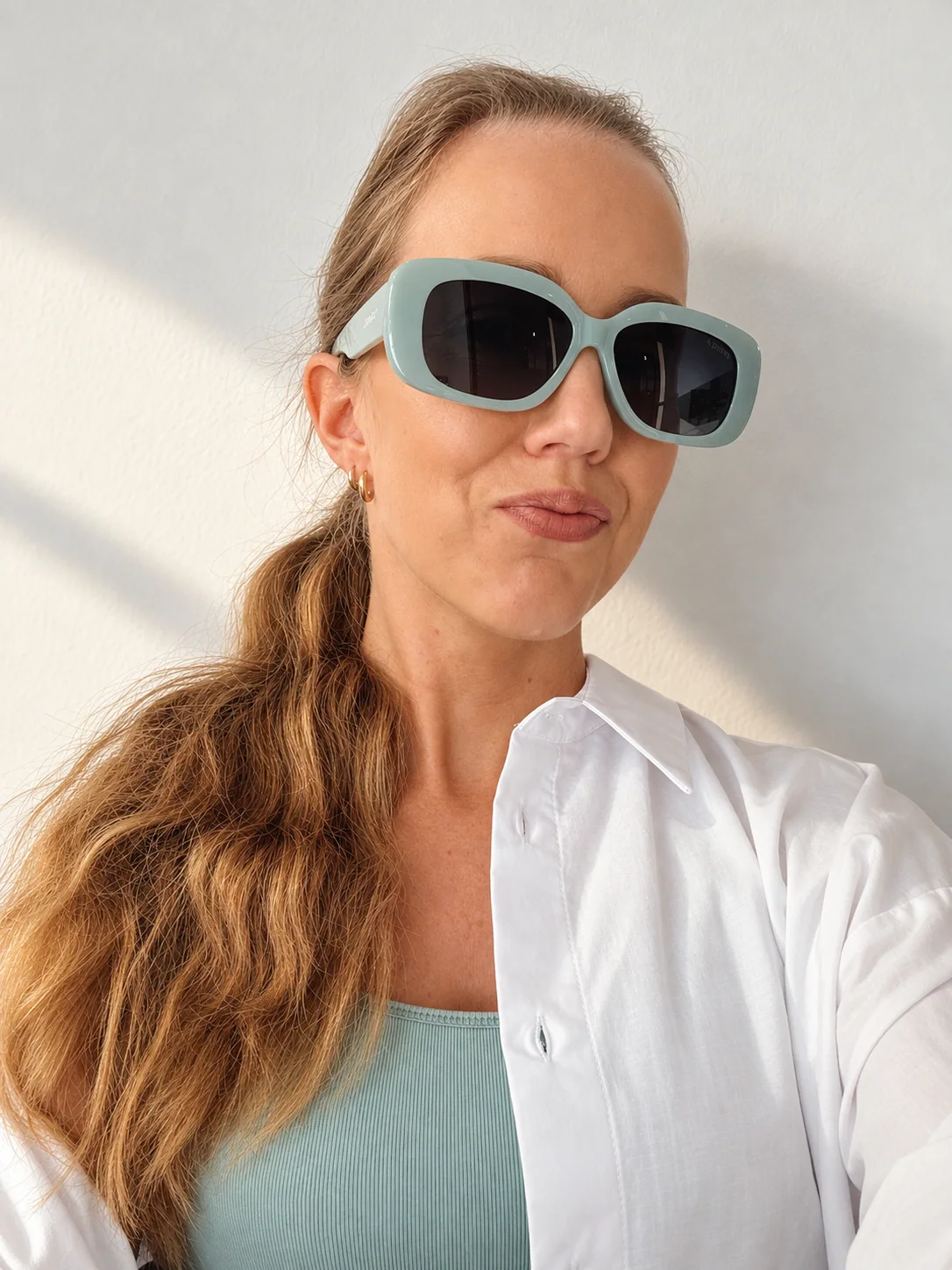 Marie Wasserman, hälsocoach, i vit skjorta och turkosa solglasögon